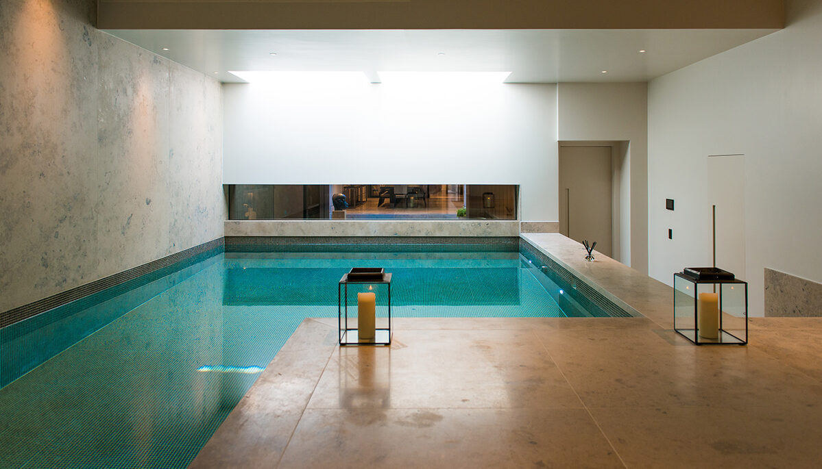 Luxury indoor wellness pool with minimalist architectural glazing and flush glass viewing window, showcasing glazing for specialist wellness spaces.