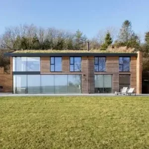 contemporary new build with oversized glazing and natural wood cladding for biophilic design