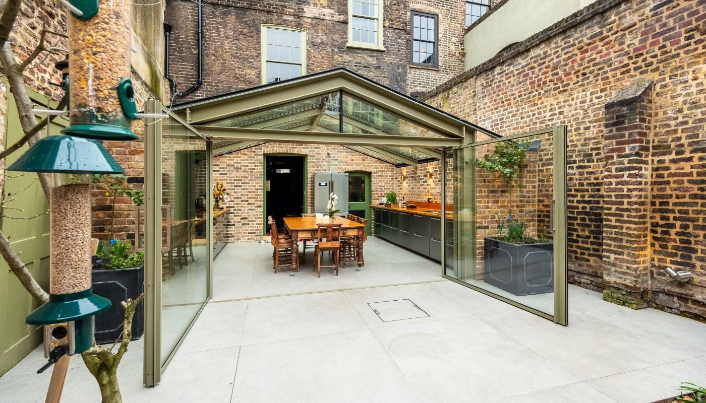 a glass extension with two large pivot doors shown open