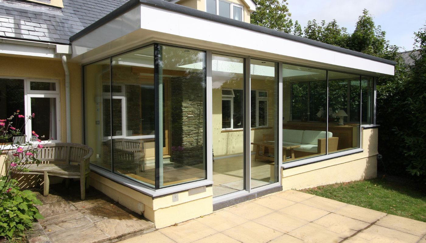 a glass orangery in cornwall using frameless glass and a flat roof