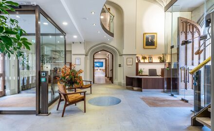 an internal view of the reception area at the pitt building in cambridge showing the glass draft lobbies