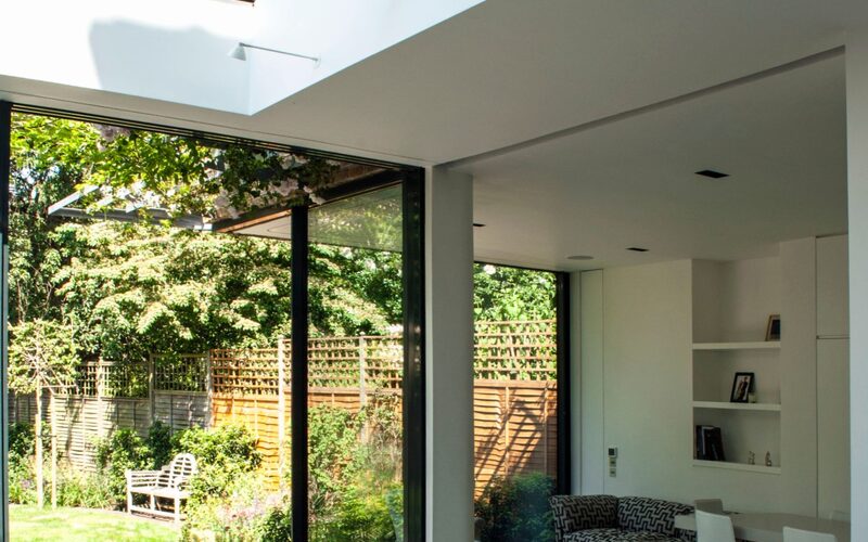 frameless glass beams to a frameless glass roof over a dining table in a rear modern extension