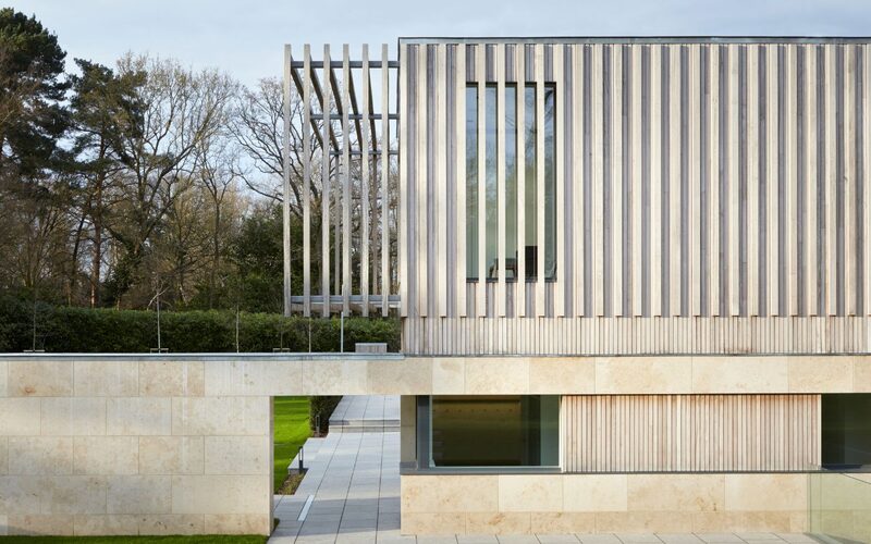 a frameless window shown from the outside of a timber clad building, with timber battens spanning over the outside of the window