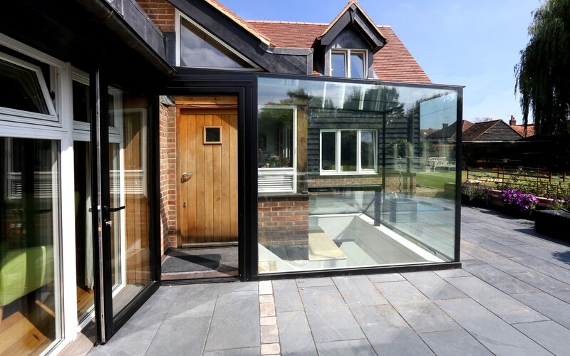 a glass box extension with an integrated door shown open
