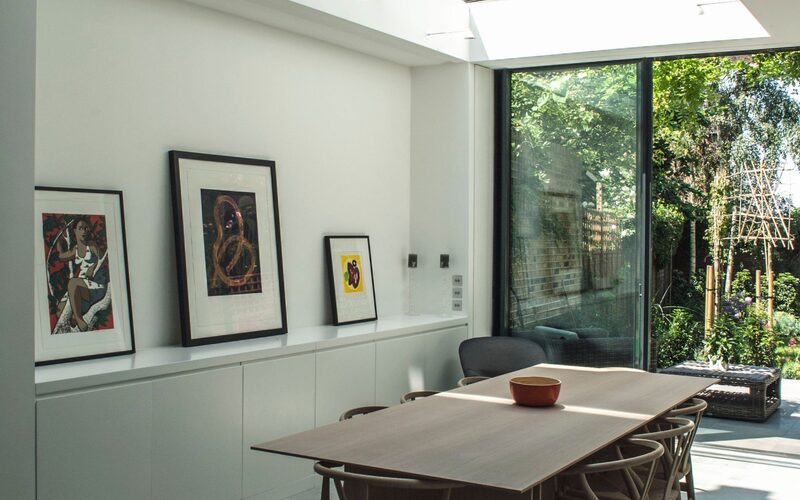 a glass rooflight with beams over a dining table