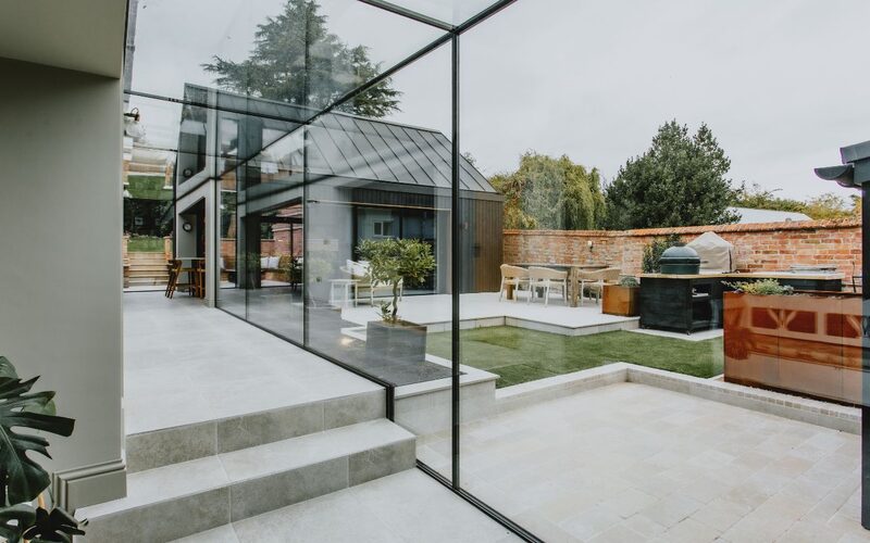 an internal look of a glass link looking out over an internal garden courtyard with the glass link notched and shaped around a stone step