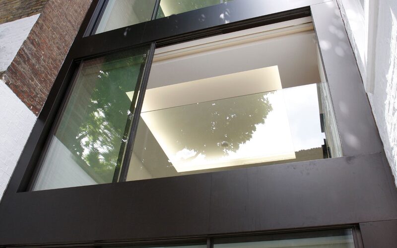 a glass Juliet balcony design as part of a large three storey glass extension in London
