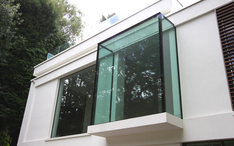 Exterior of a structural glass oriel window with a glazed roof at White Lodge, Surrey