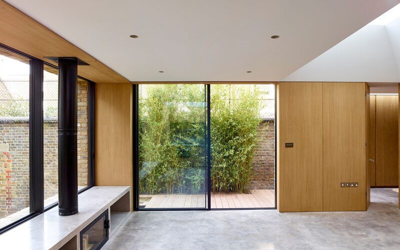 a two panel slim framed patio door surrounded by oak cladding shown from the inside with one panel slid open