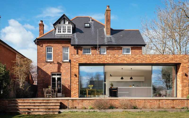 slim glazed doors in a brick extension open in the middle