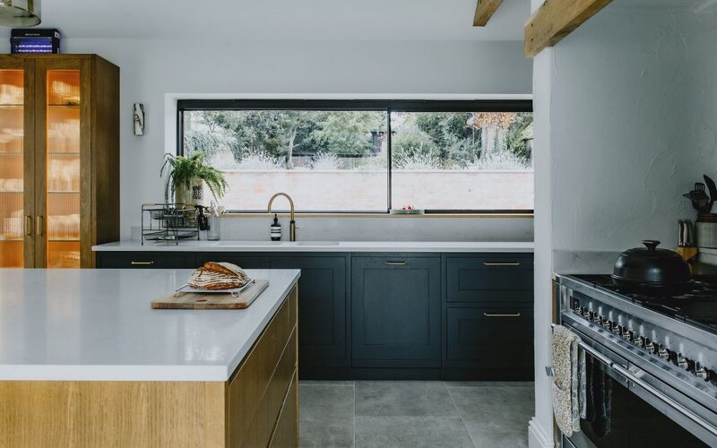 a slim framed sliding window over a sink looking out to a garden