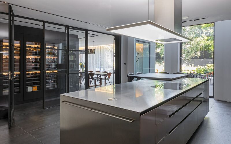 a kitchen with steel internal doors between the kitchen and wine cellar
