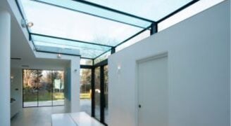 a large glass roof over a side infill extension with white walls