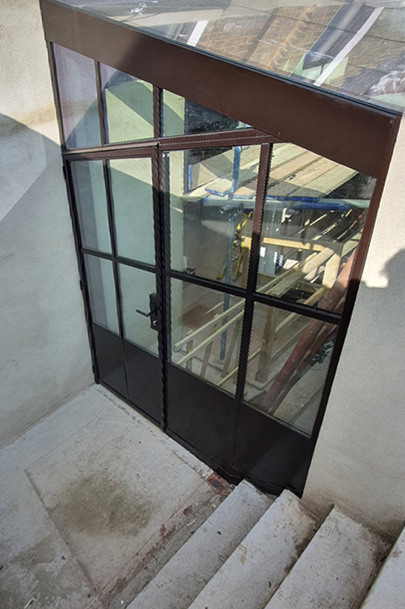 black brown double doors with glass roof extension